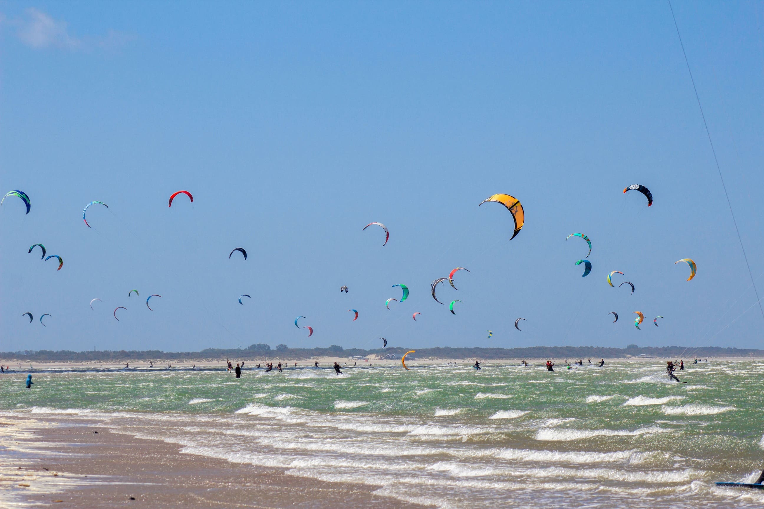 Aktivurlaub in Europa Viele Kitesurfer auf dem welligen Meer