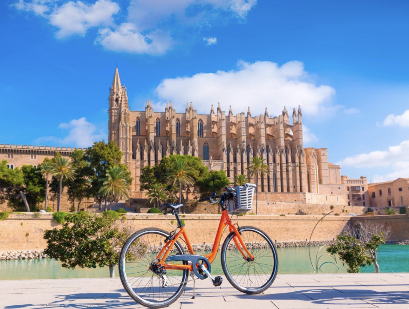 Ein rotes Fahrrad steht vor der Kathedrale in Palma de Mallorca.