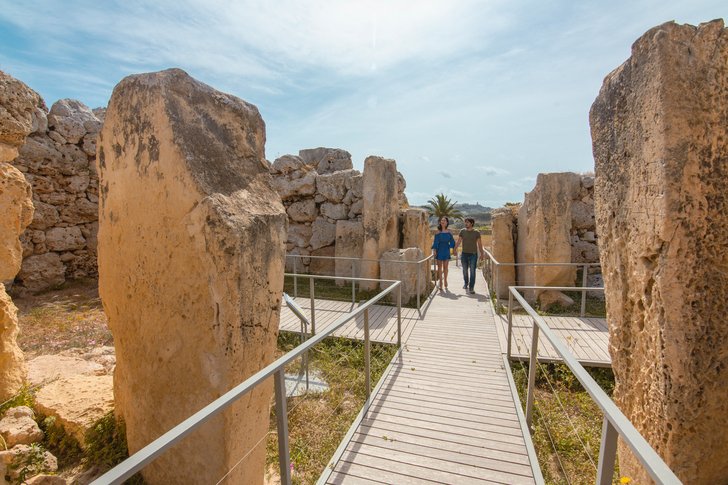 gozo-ggantija-tempel zwei-menschen-laufen-durch-alte-ruinen