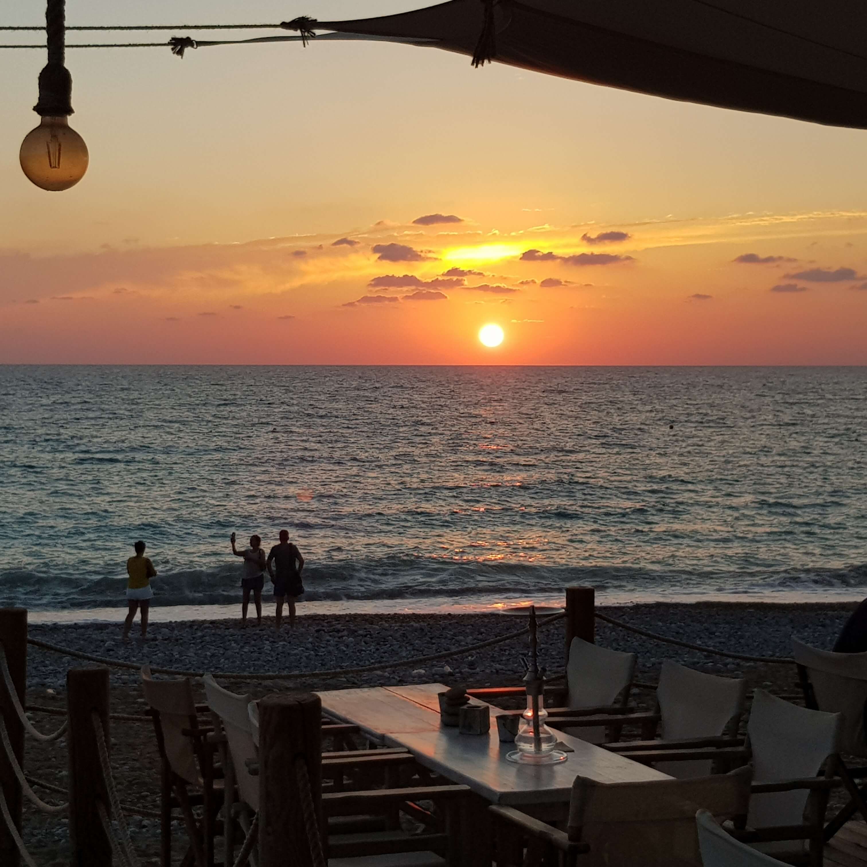 Zypern Urlaub Menschen am Meer beobachten den Sonnenuntergang