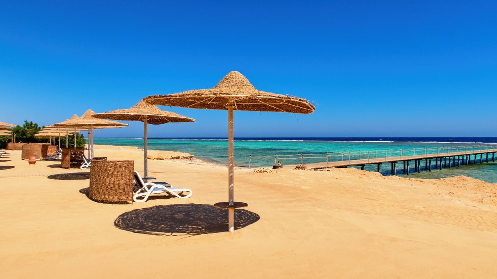 goldgelber-strandabschnitt-mit-sonnenschirmen
