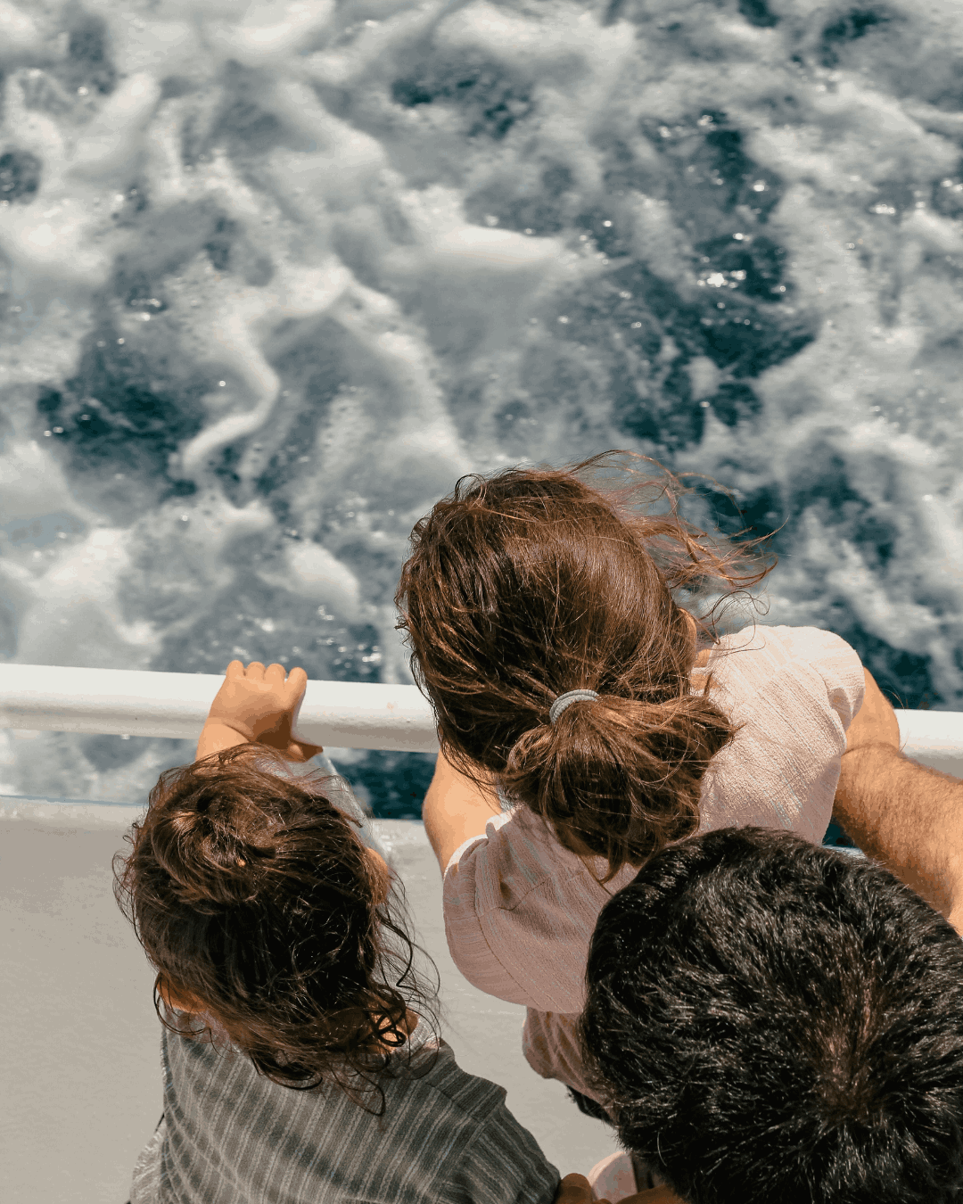 kreuzfahrt-kinder-aussicht Zwei Kinder stehen am Rand einer Reling und blicken herunter auf das Wasser