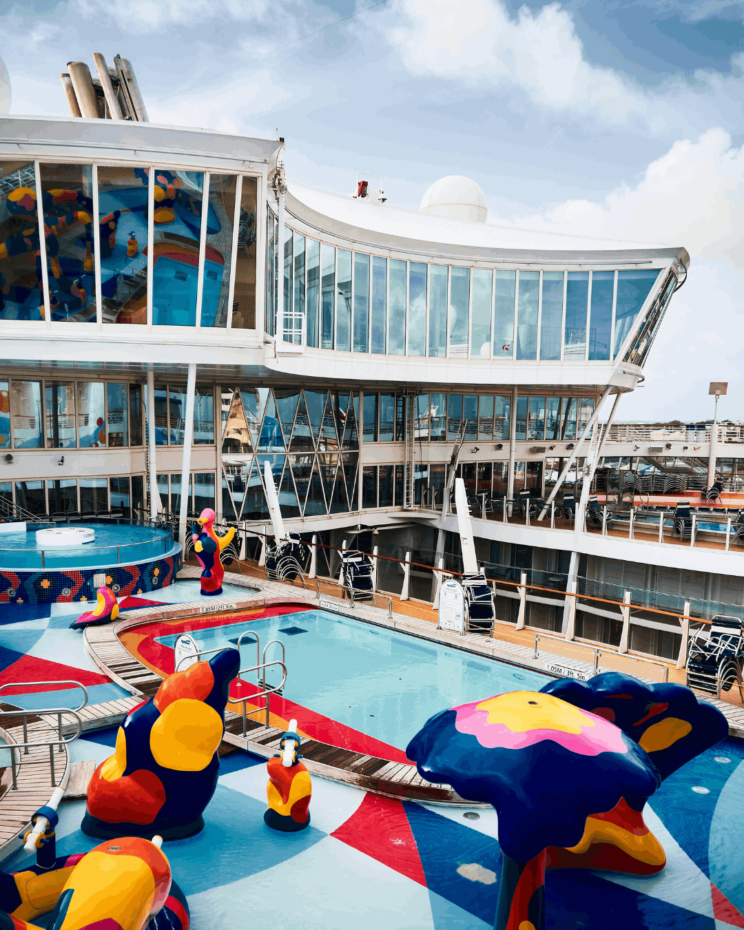 kreuzfahrt-poolbereich Ein Poolbereich an Deck eines Kreuzfahrtschiffs mit vielen bunten Figuren für Kinder