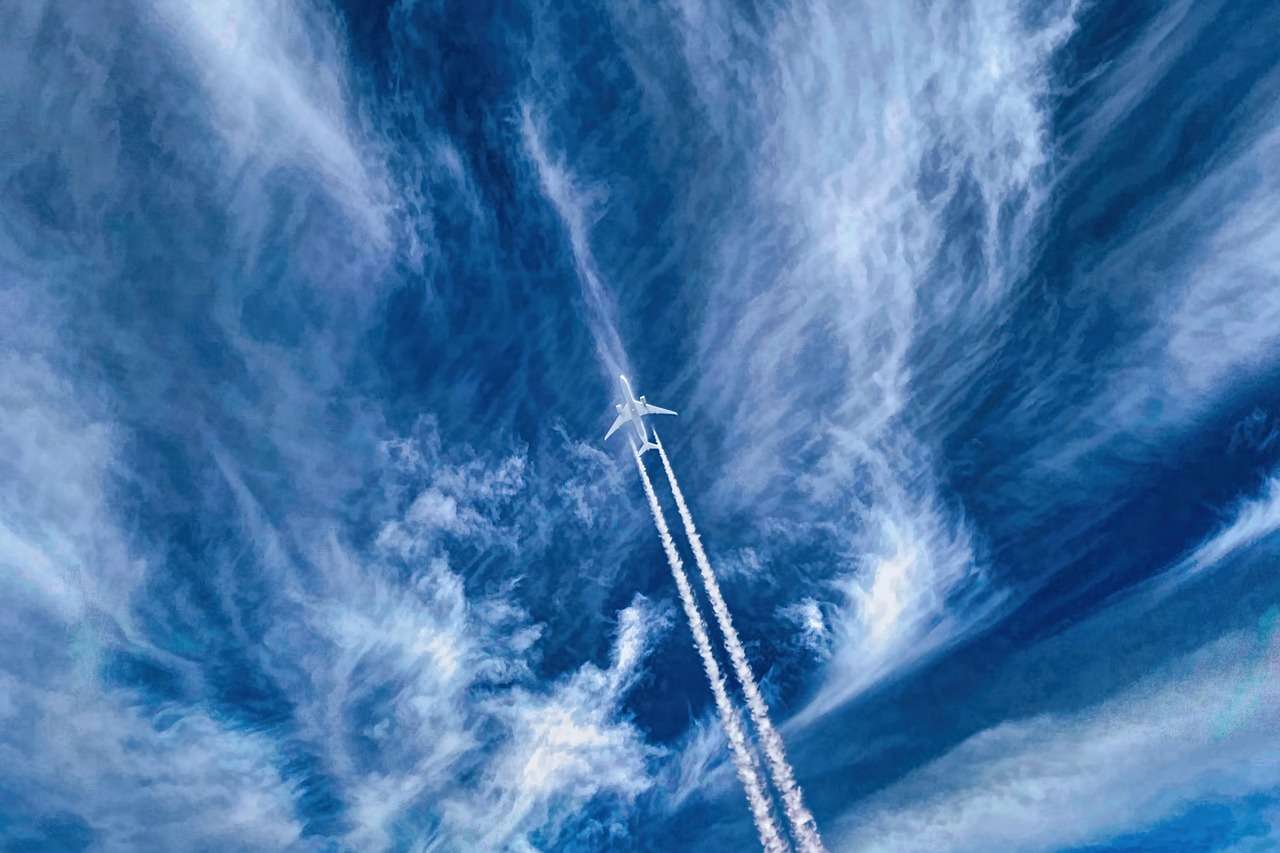 flugzeug-am-himmel flugzeug-fliegt-am-blauen-himmel-mit-kondenzstreifen