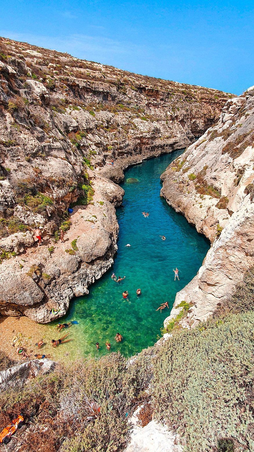 gozo-bucht zwischen-steilen-klippen-schwimmen-menschen-im-türkis-blauen-wasser