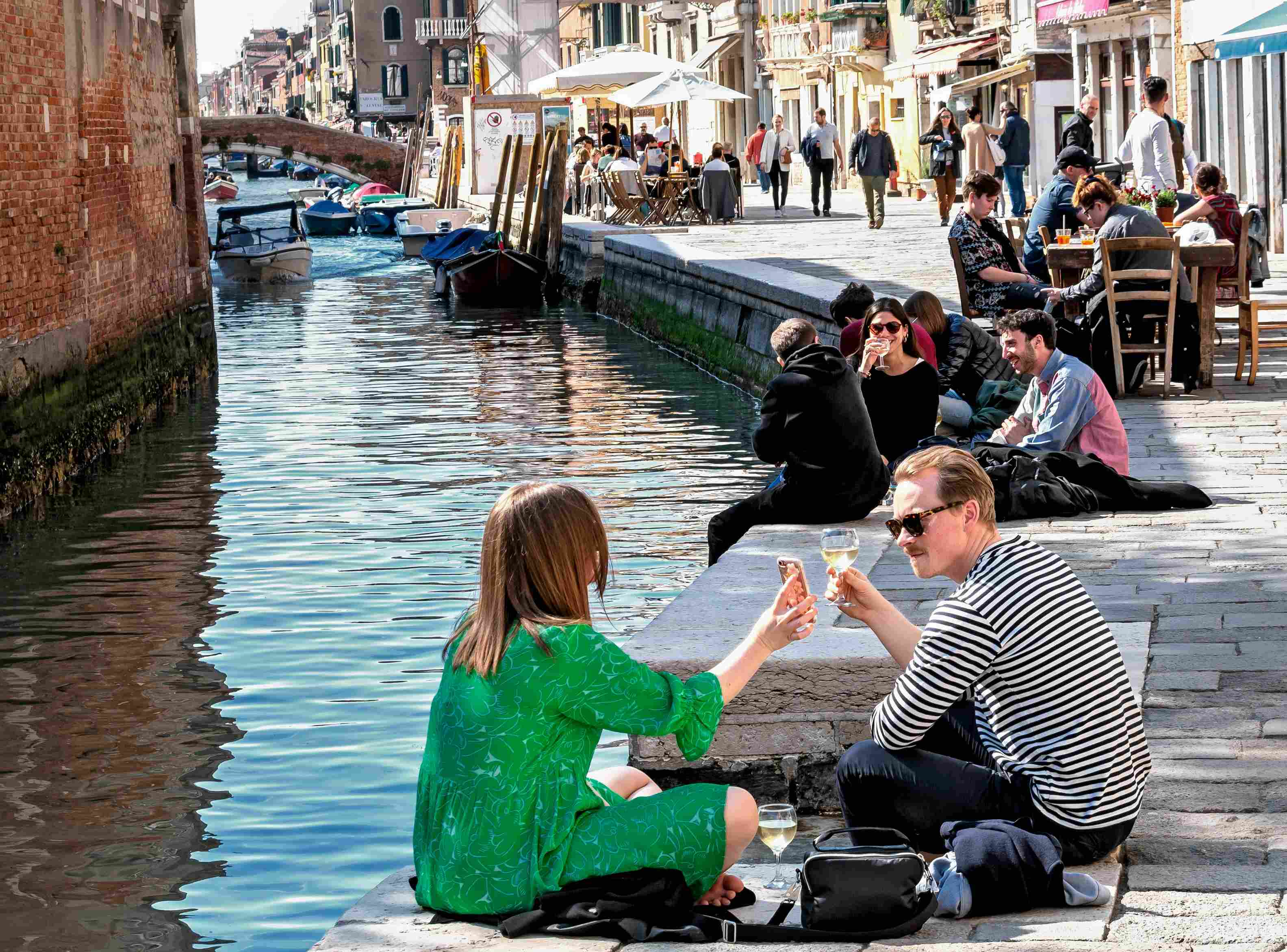 italien-atomsphaere-kanal An einem Kanal sitzen Menschen mit Weingläsern und unterhalten sich