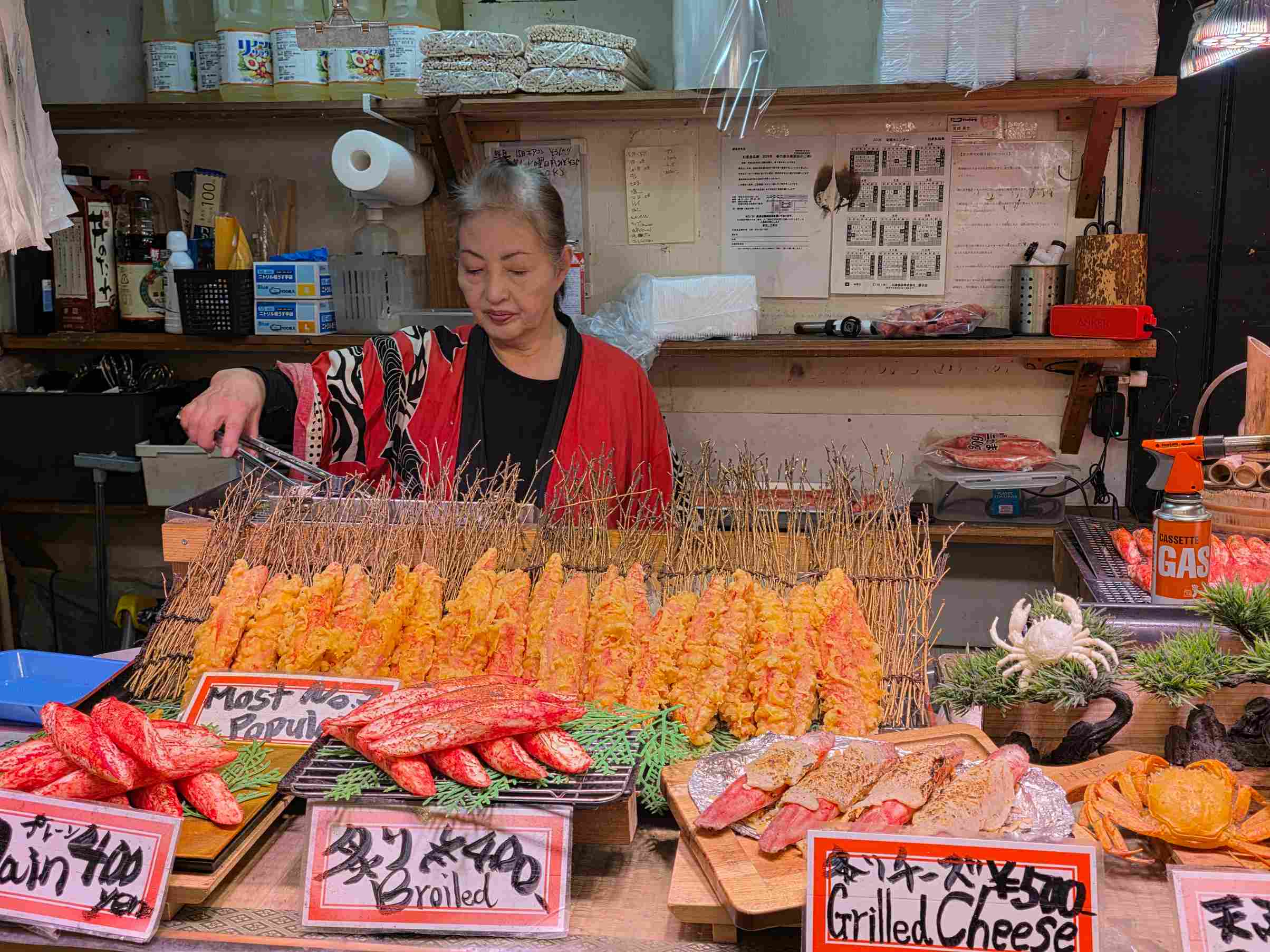 Eine ältere japanische Frau an einem Marktstand