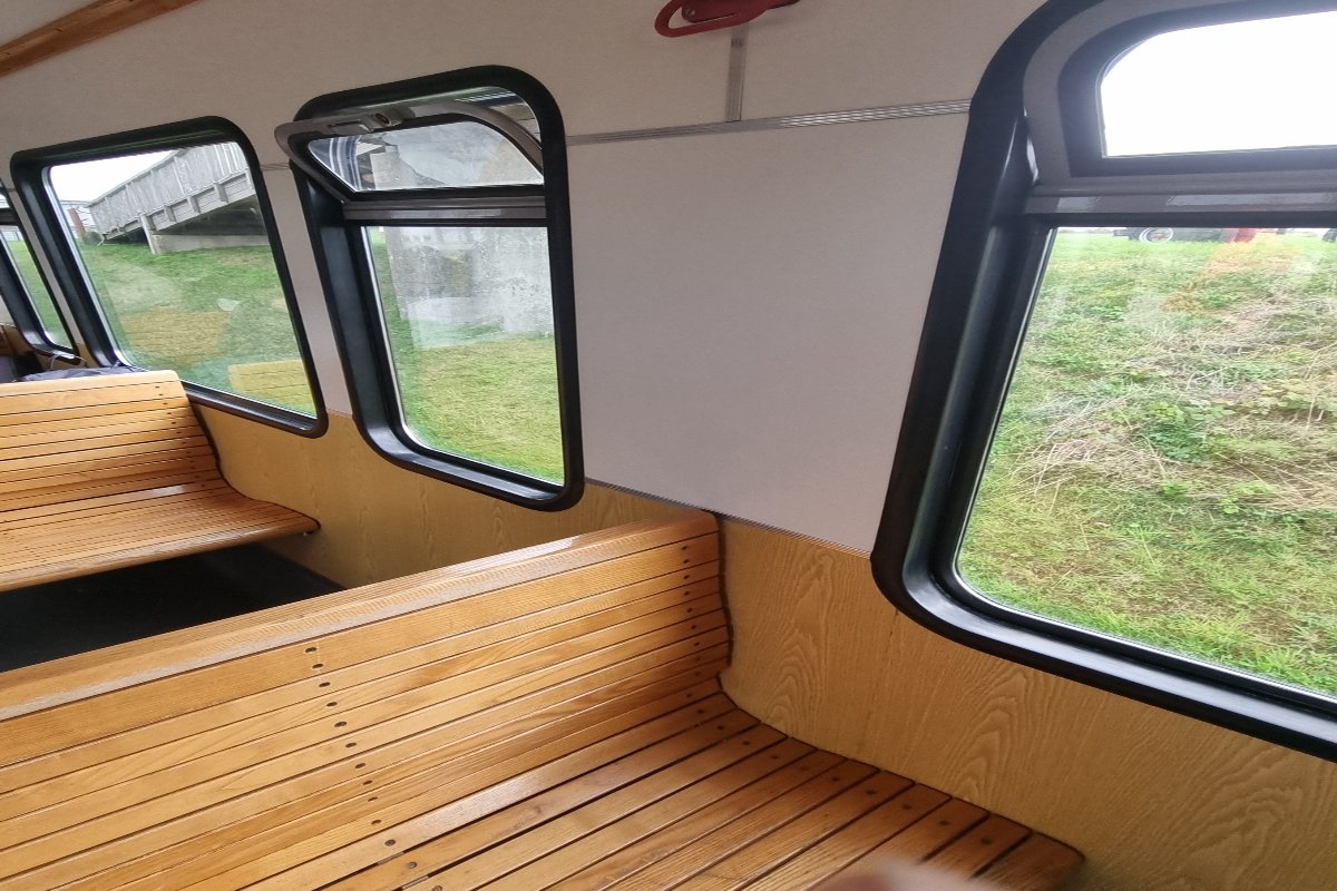 Innenraum mit Holzbänken der Inselbahn Langeoog