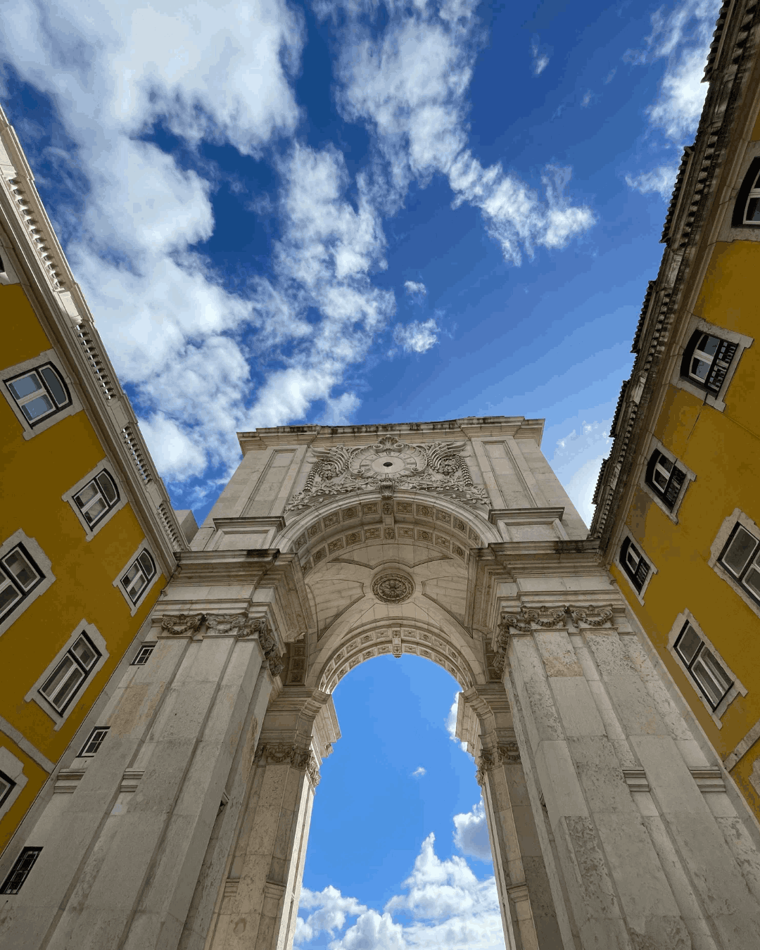 Eine riesiges, historisches Tor, grenzt an gelbe Hausfassaden