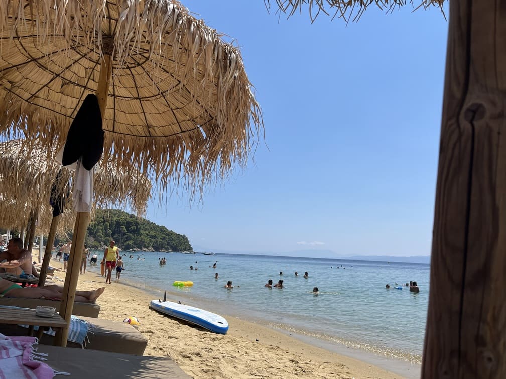 skiathos-strand Achladies Ein ruhiger Strand mit Sonnenliegen an weißen Häusern