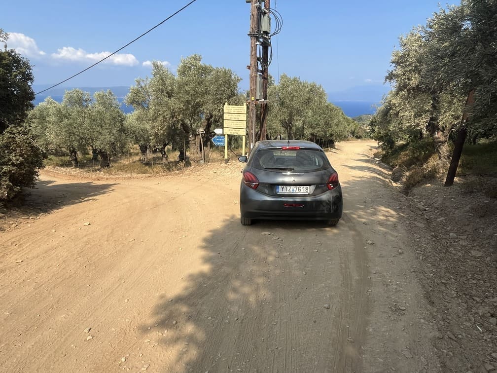 mietwagen-auf-skiathos Ein kleines Auto fährt auf einer nicht präparierten Straße
