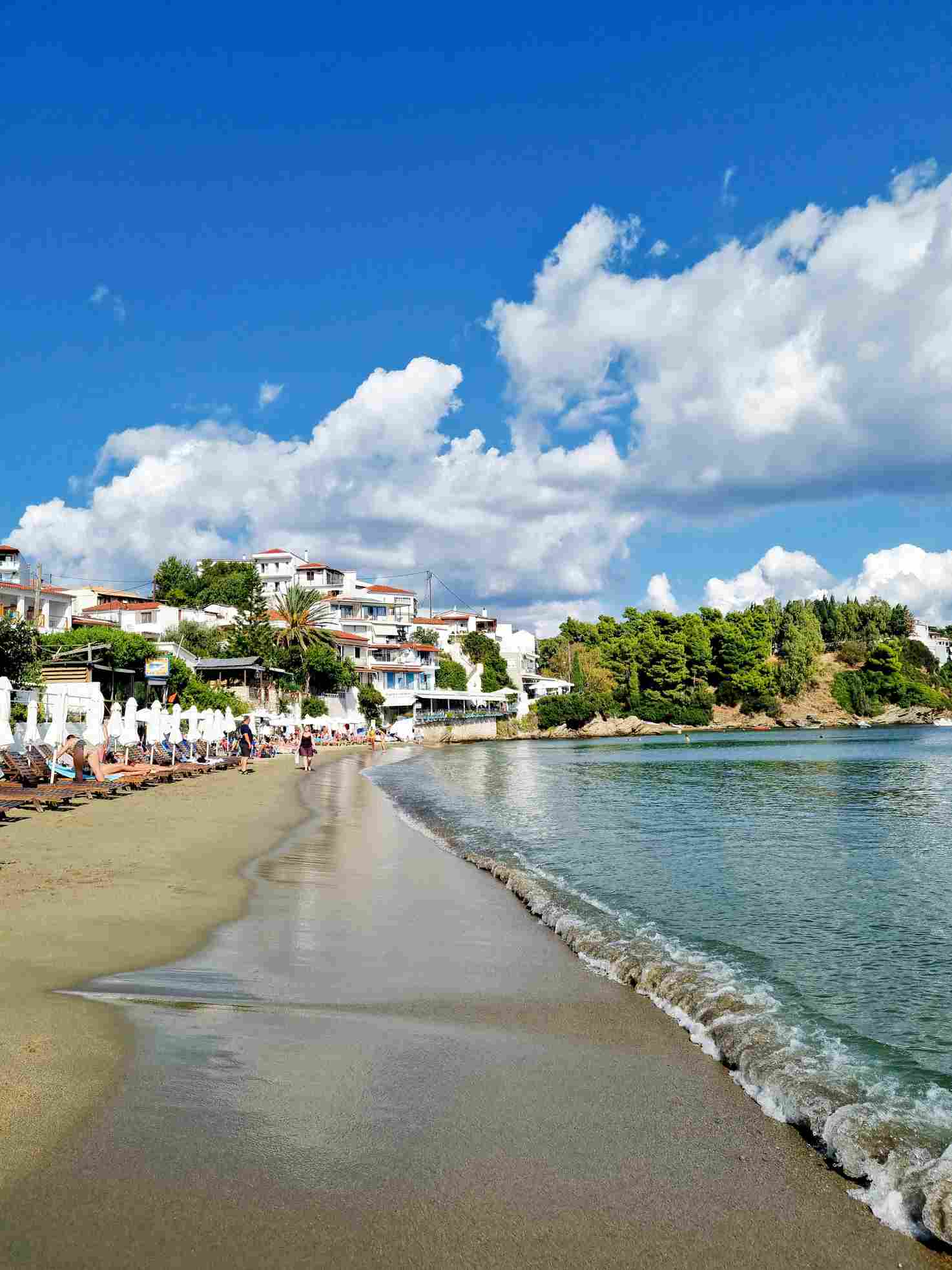 Ein ruhiger Strand mit Sonnenliegen an weißen Häusern