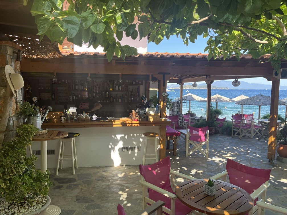 Skiathos Urlaub Offene Strandbar mit pinken Stühlen