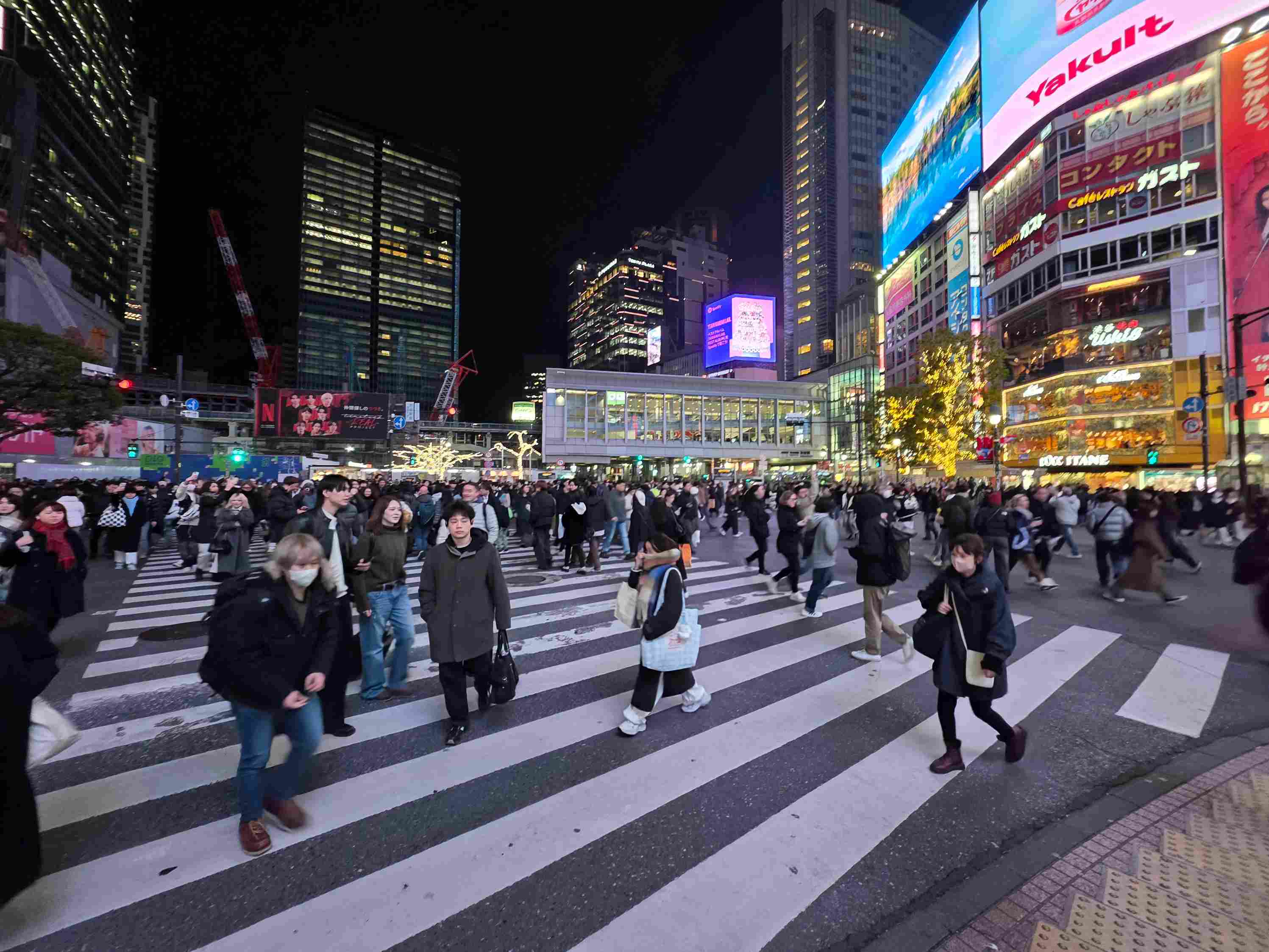 Eine belebte Kreuzung in Tokio zwischen großen, digitalen Werbebannern