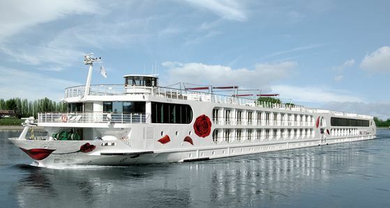 flusskreuzfahrten-europa-a-rosa-seine Ein weißes Flusskreuzfahrtschiff der Reederei A-ROSA mit roten Blüten auf der Seine