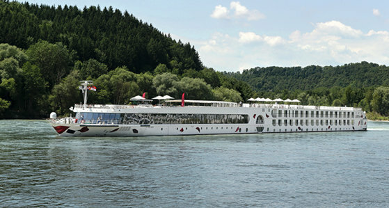 Ein weißes Flusskreuzfahrtschiff der Reederei A-Rosa auf einem glatten Fluss
