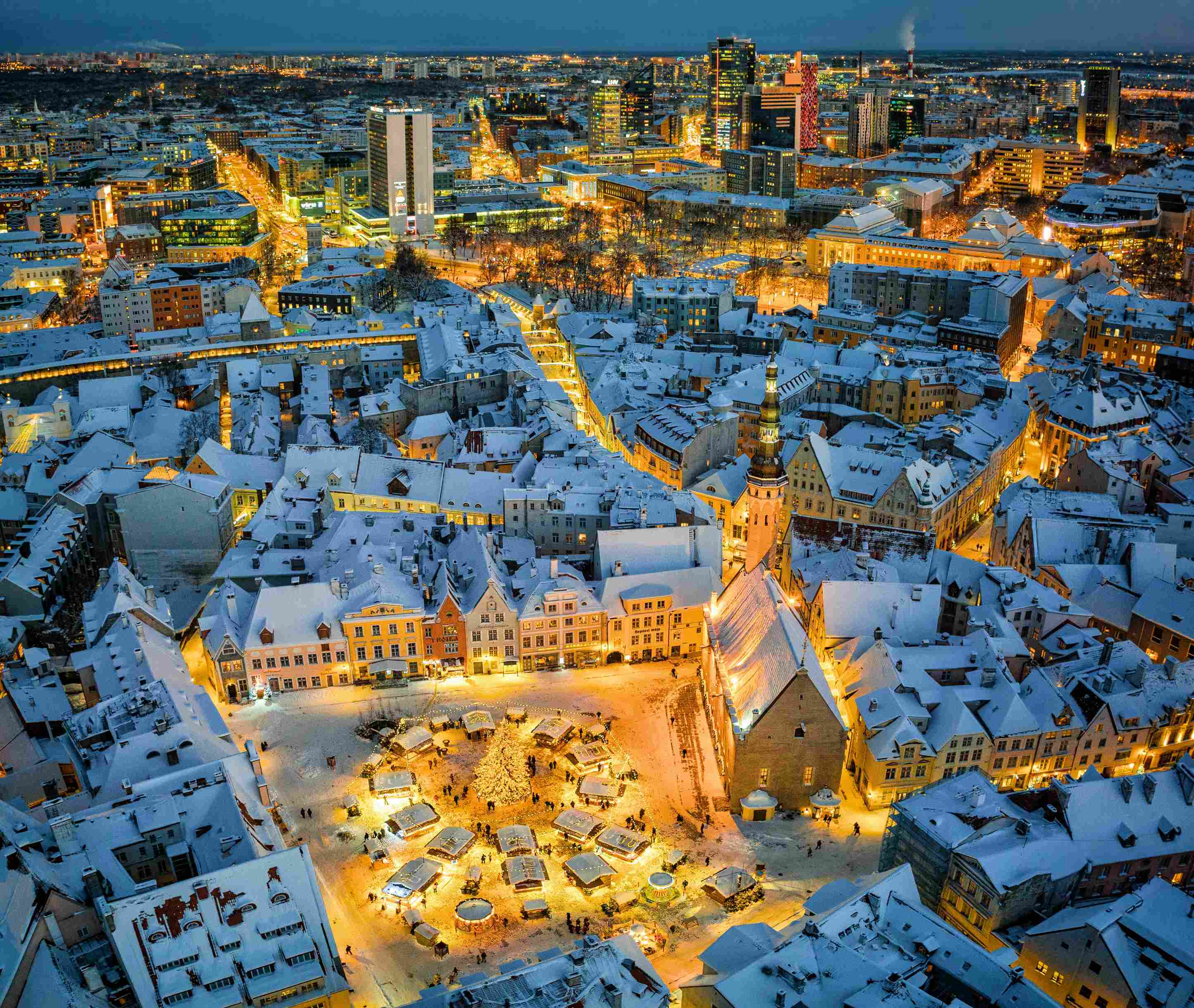 flusskreuzfahrten-winter-weihnachtsmarkt Eine verschneite Stadt von oben, in der Mitte ein weihnachtlich beleuchteter Platz