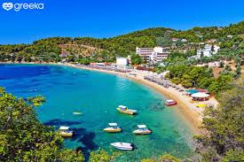 Blick auf Strandbucht mit Hotels, Sonnenliegen und Ausflugsbooten