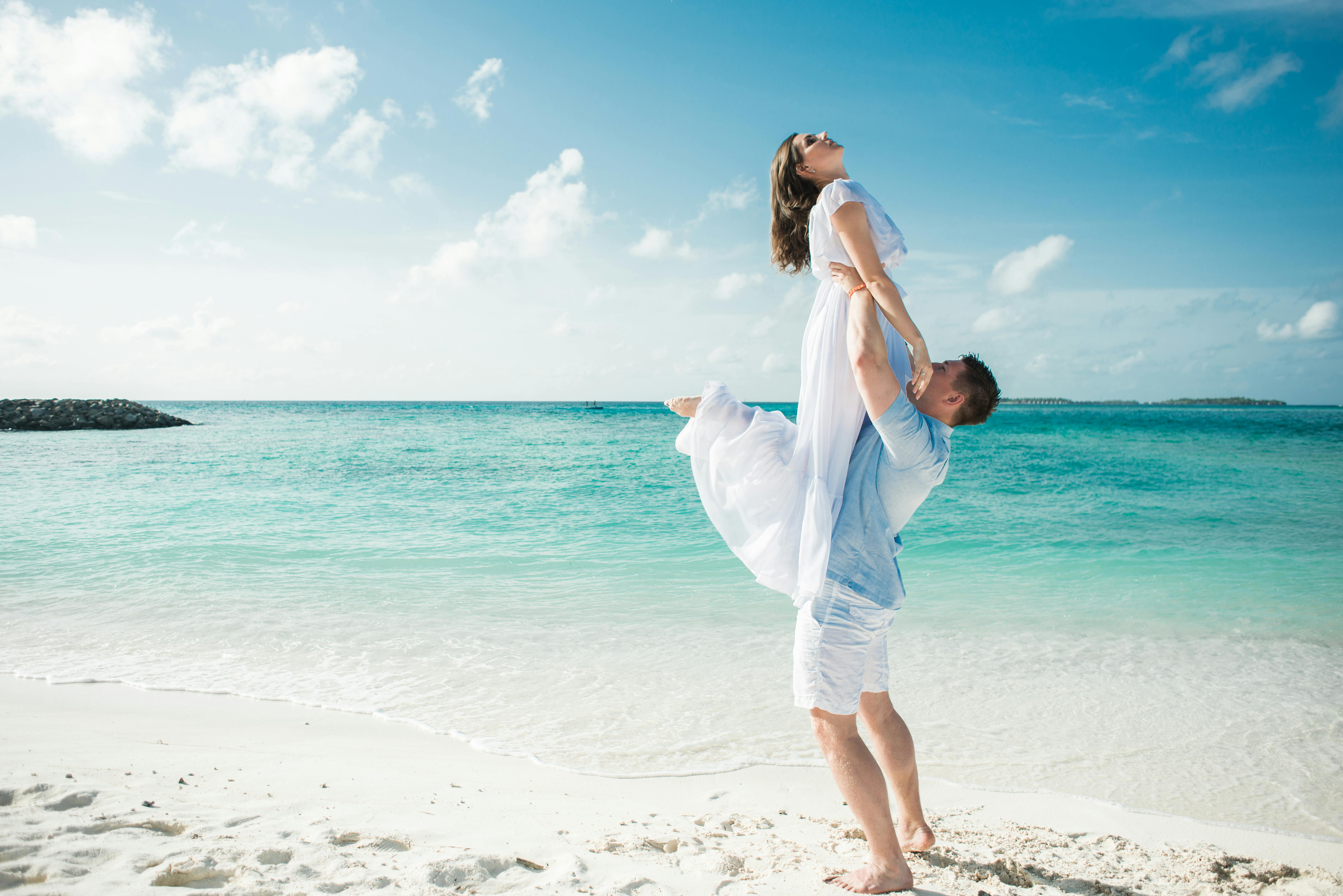 Paar am Sandstrand mit azurblauem Wasser