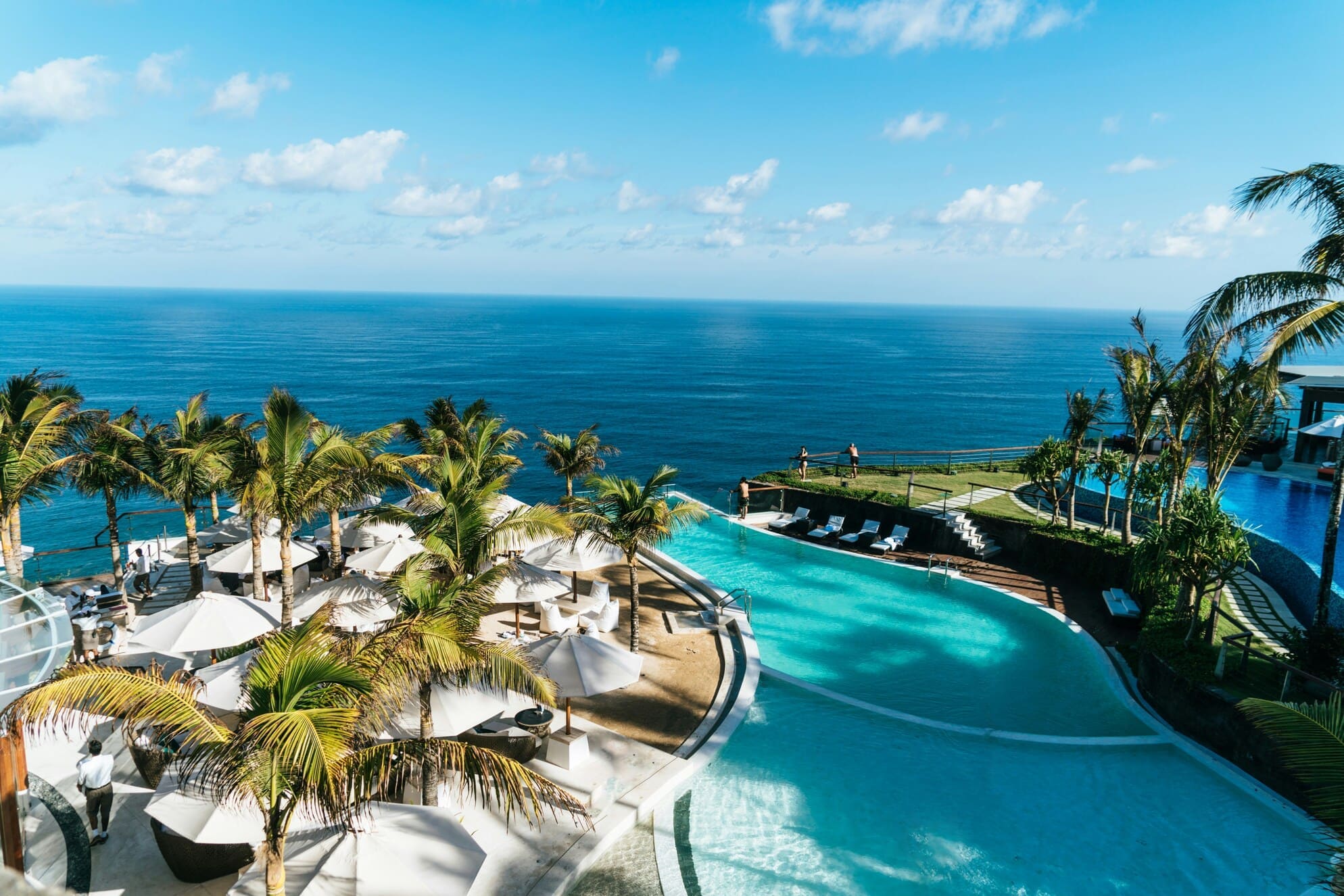 Poollandschaft mit Palmen am Meer
