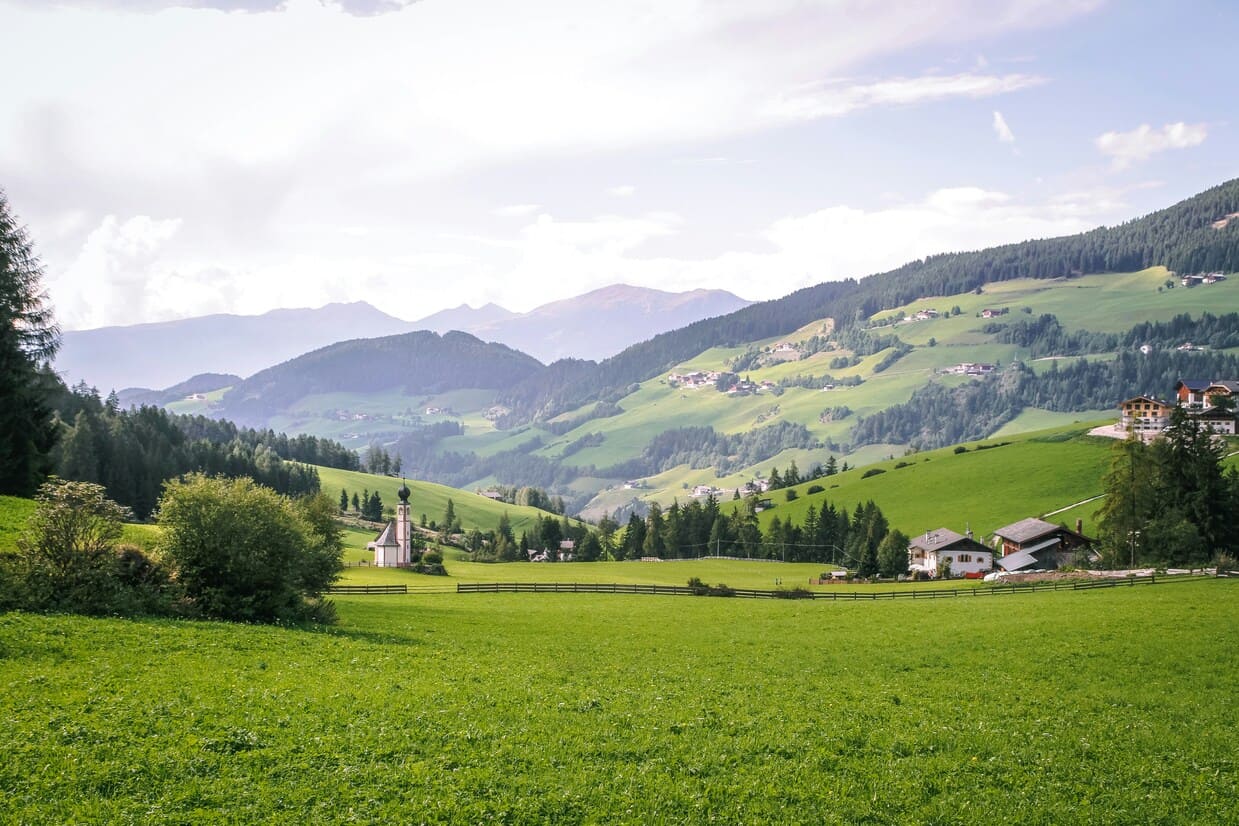Urlaub in Österreich Grüne hüglige Berglandschaft mit einer Wiese