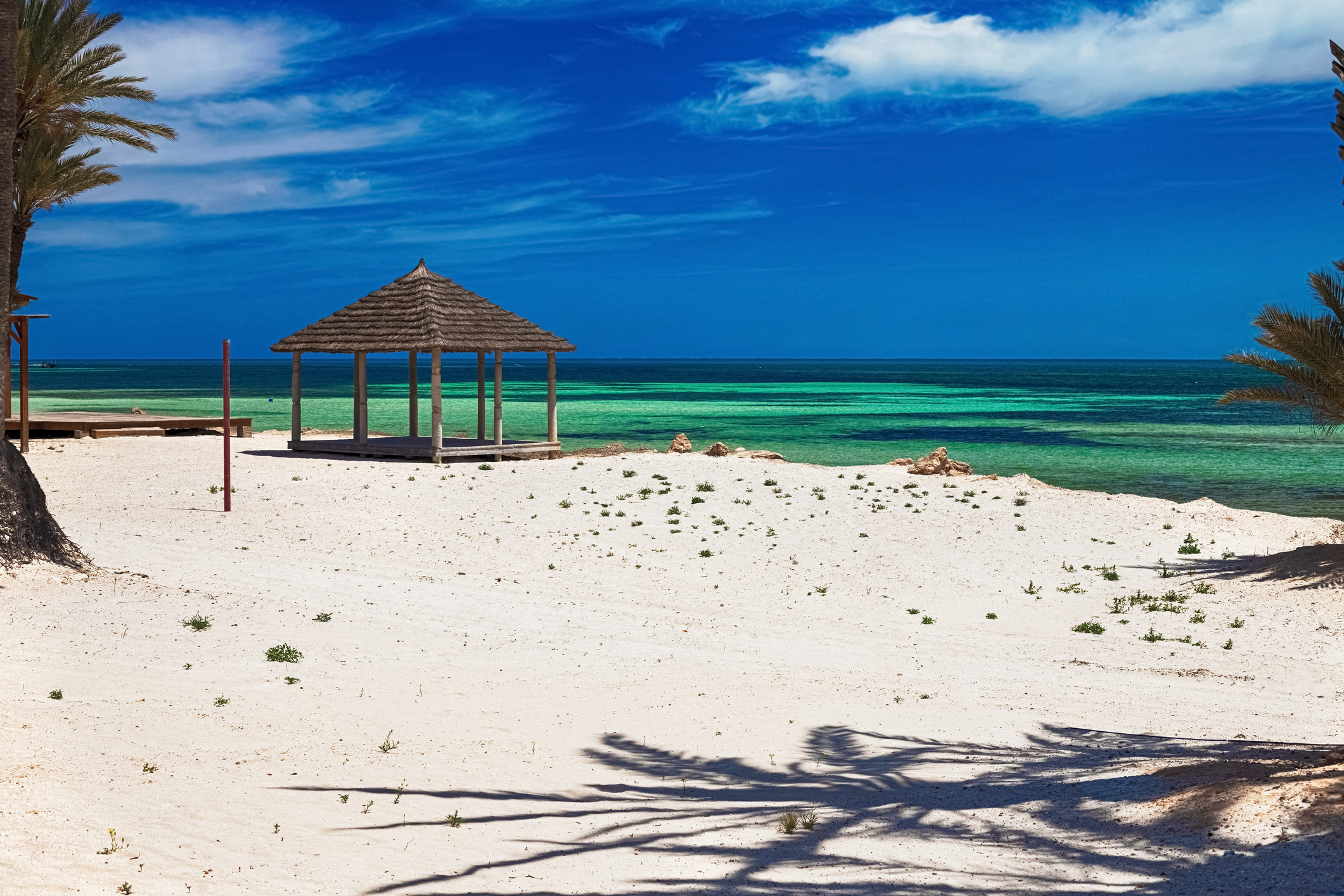 Weißer Strandsand mit Palme und türkisfarbenen Meer