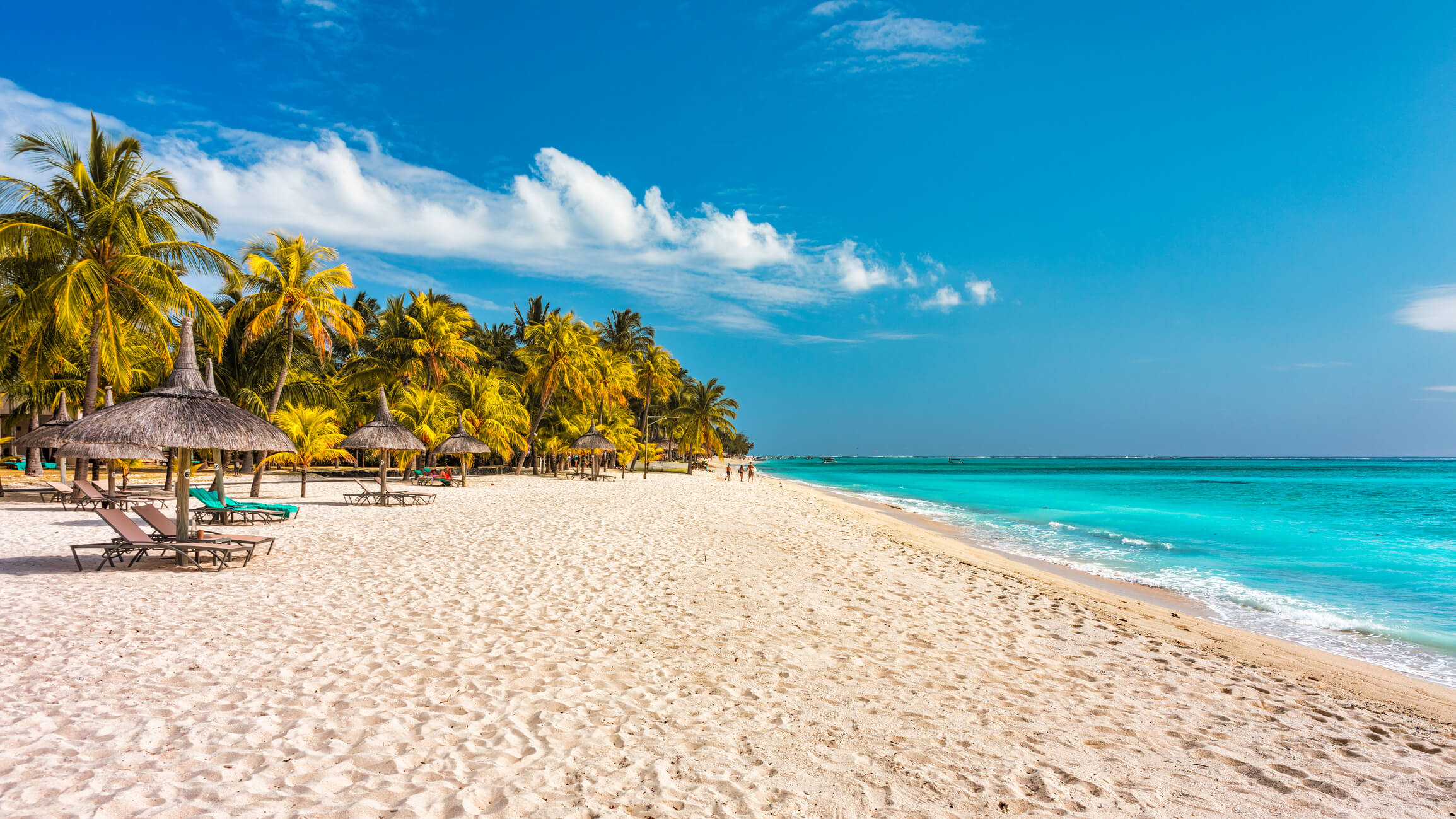 Feinsandiger Strand mit Sonnenschirmen im Mauritius Urlaub