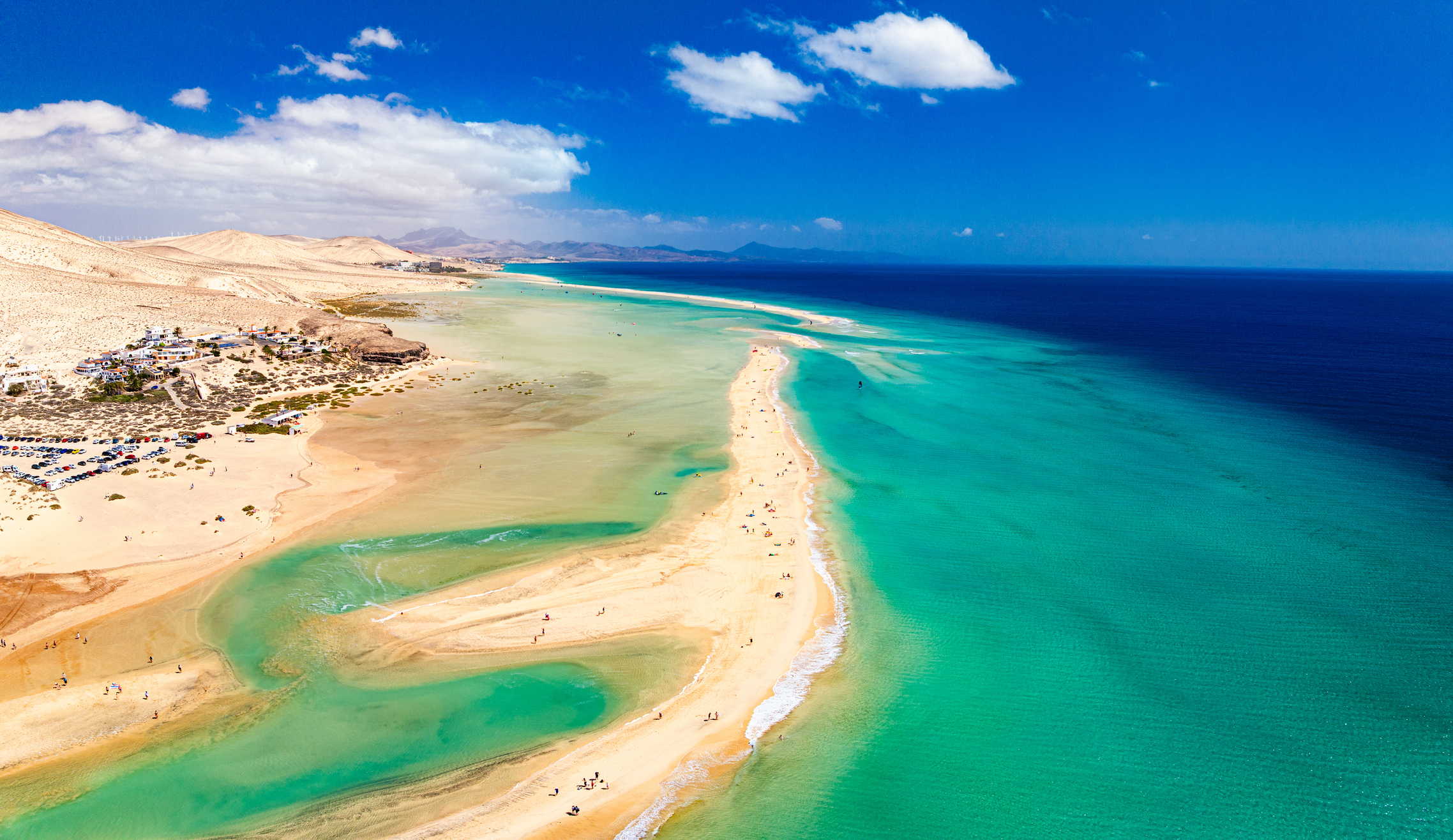 Strand auf Fuerteventura Lagune mit Treibsand und grün schimmerndem Wasser sowie Sanddünen