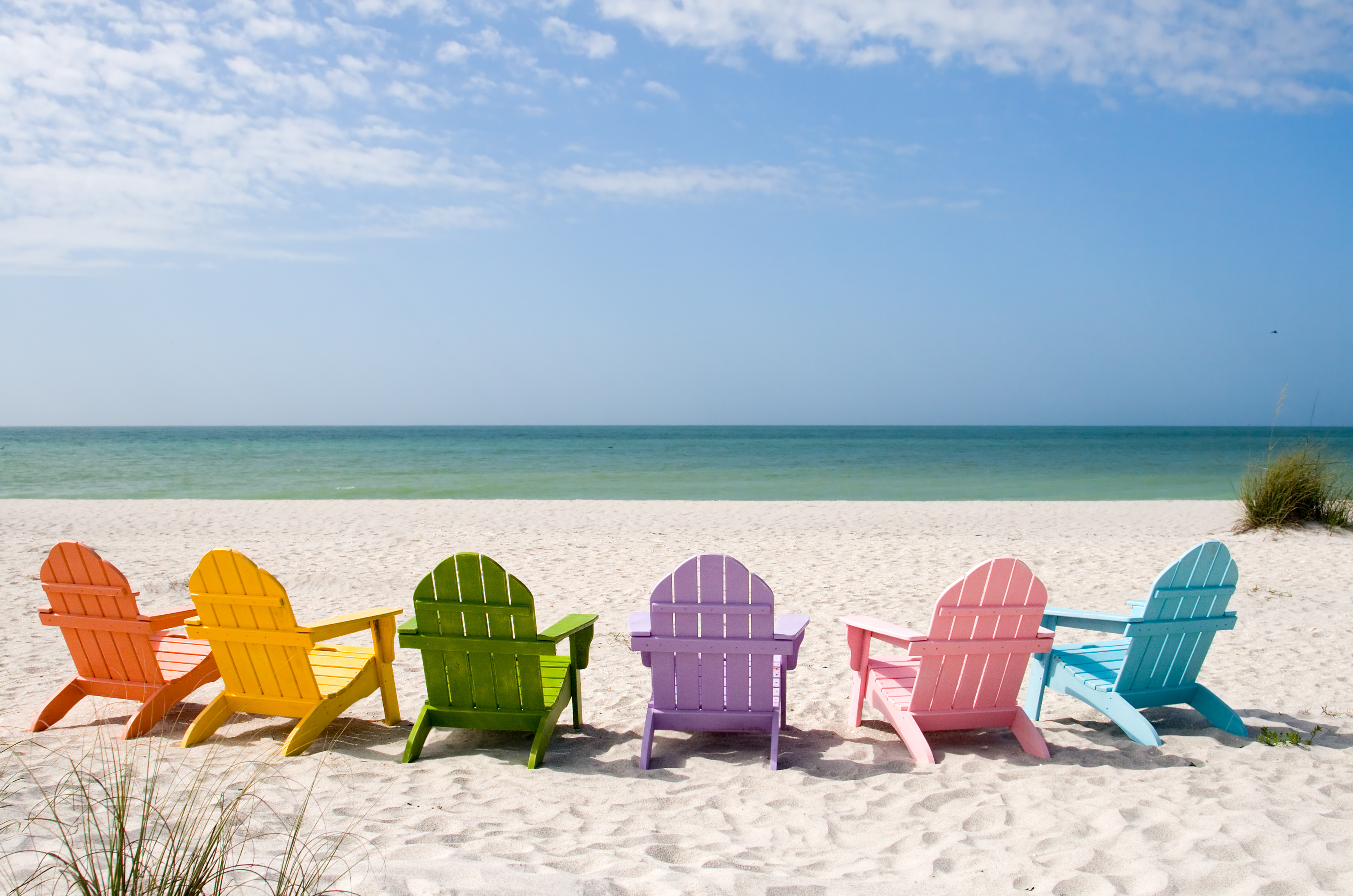 Urlaub Florida Typisch amerikanische bunte Strandstühle stehen an einem menschenleeren Strand mit Meerblick