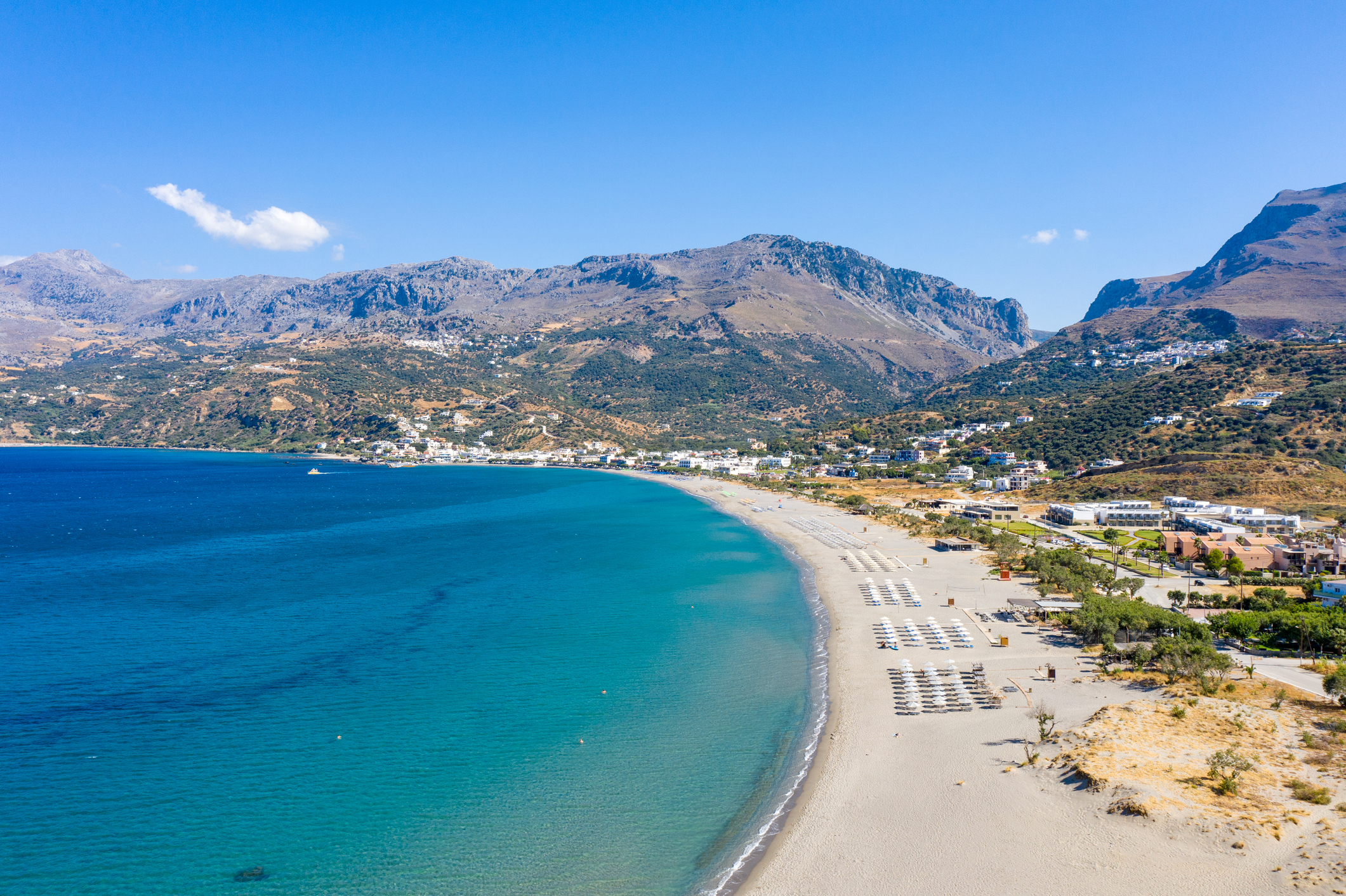 Kreta lange Strandbucht mit hellem Sand und Berrgen im Hintergrund