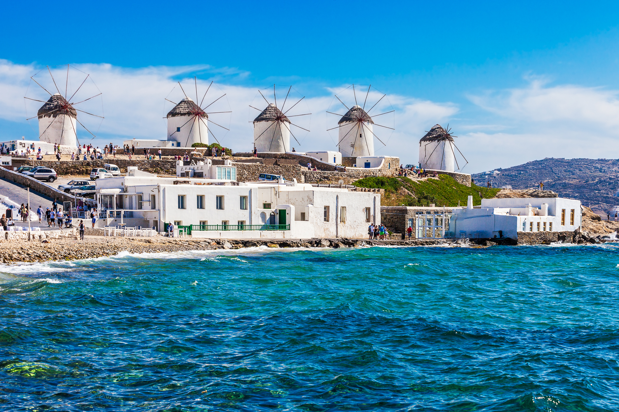 Windmühlen am Hafen von Mykonos mit typisch griechischen Häusern und Tavernen