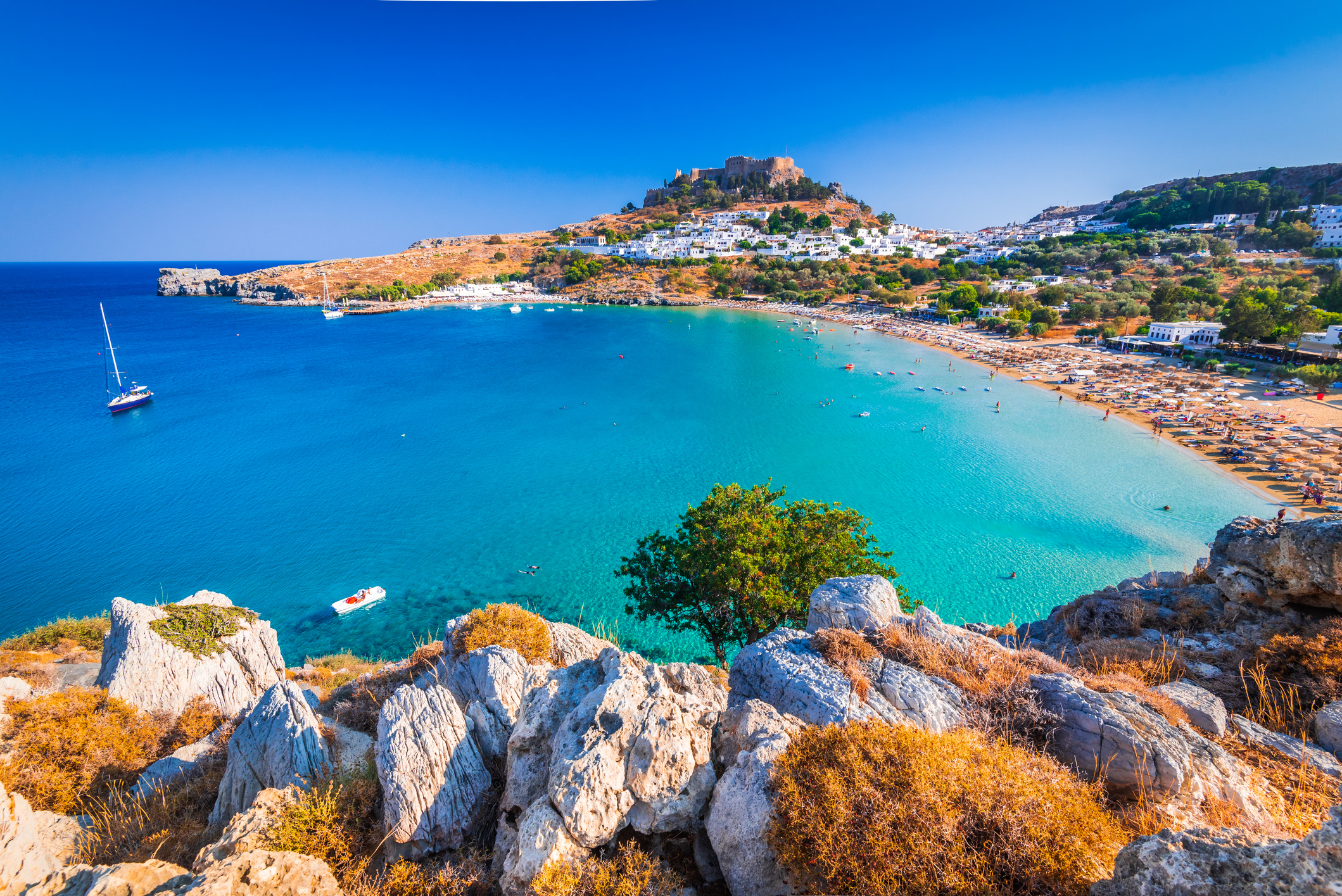 Blick auf das Dorf  Lindos in einer Bucht mit einer Akropolis auf einem Berg