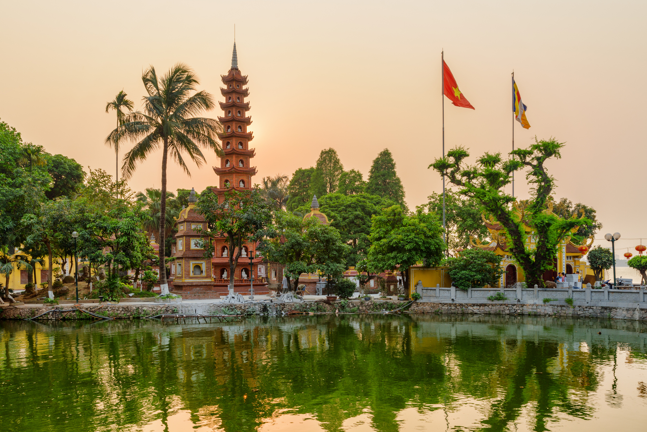 blick auf die Tran Quoc Pagode in Hanoi im Abendlicht mit Palmen