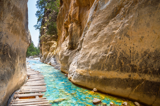 Kreta Samaria Schlucht Blick in eine Schlucht mit kleinem Fluss in der Mitte und einem Holzweg hindurch