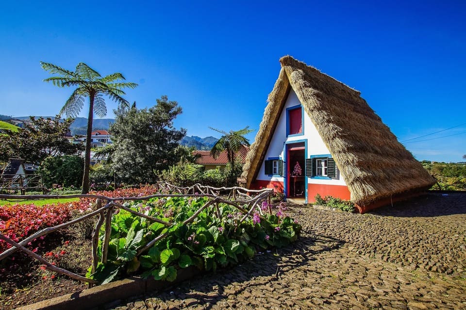 Urlaub auf Madeira Eine typisches altes Bauernhaus mit Stroh gedecktem Dach und einer Palme