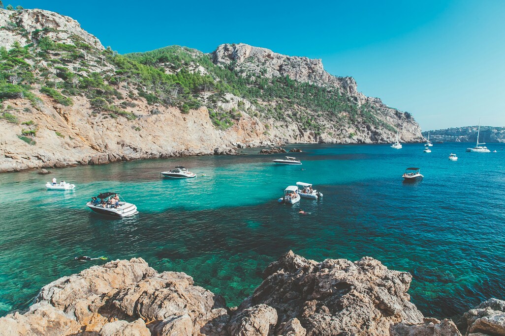Romantische Felsenküste mit Booten und Meer