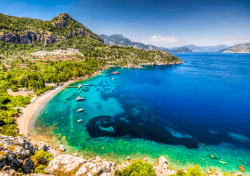 Kleine Strandbucht mit grün bewachsenem Hinterland leicht felsig