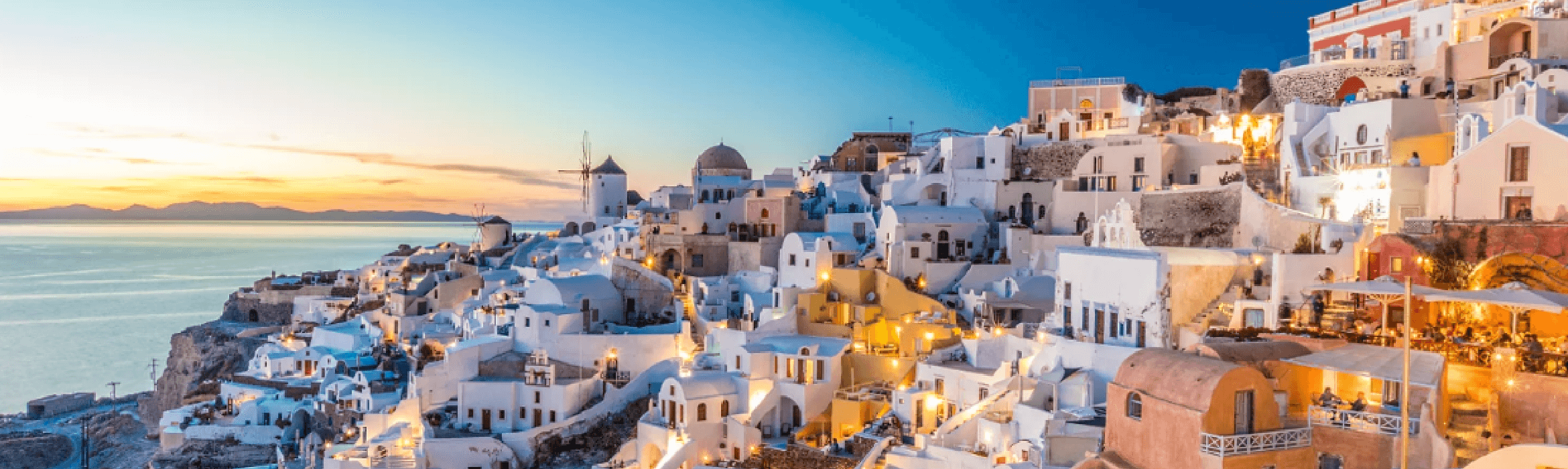 Urlaub in Griechenland im Juli Typische weiß blaue Häuser an einem Kraterrand im Abendlich