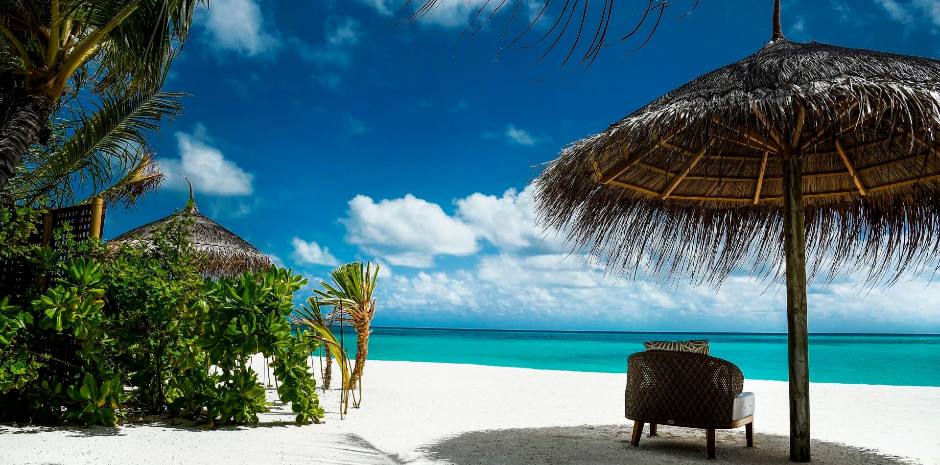 Urlaub auf Kuba Menschenleerer Traumstrand mit Palmen uns Sonnenschirm direkt am Meer